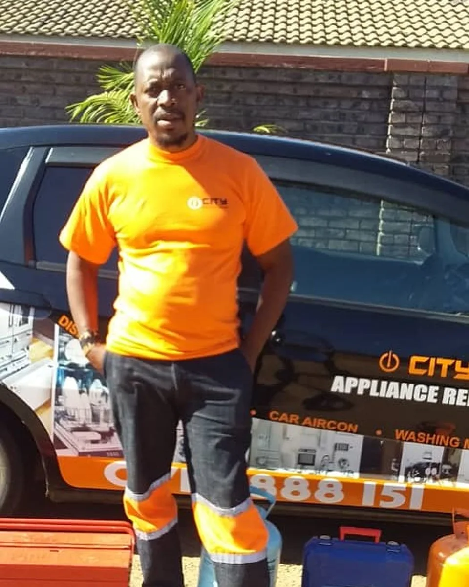 City Appliance Repairs technician standing beside the branded service vehicle