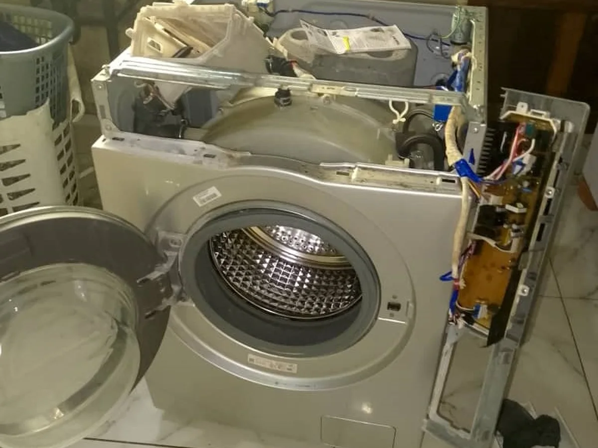 Front-loading washing machine with its panels removed during a repair