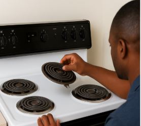 Hand adjusting a coil element on an electric stove